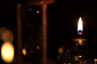 Close-up of lit candle in dark room