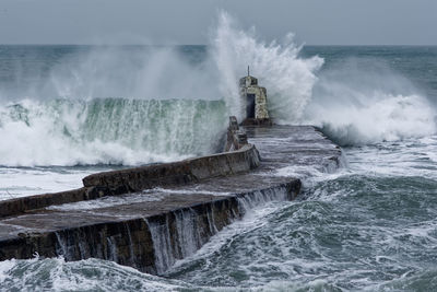Stormy seas breaking over a pier.