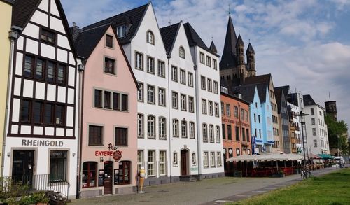 Residential buildings by street against sky