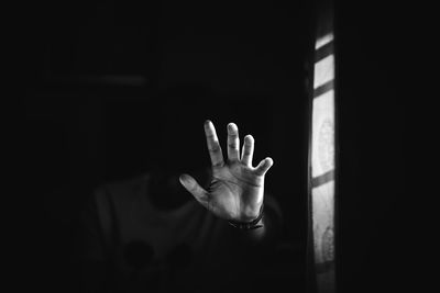 Young man gesturing in darkroom