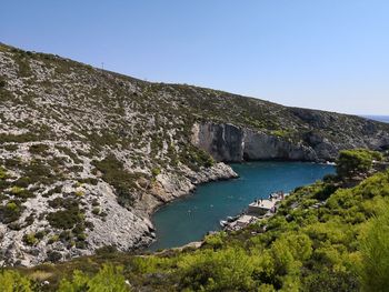 Scenic view of sea and mountains against clear blue sky