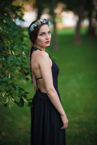 Young woman looking away while standing on land