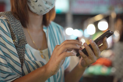 Midsection of woman using mobile phone