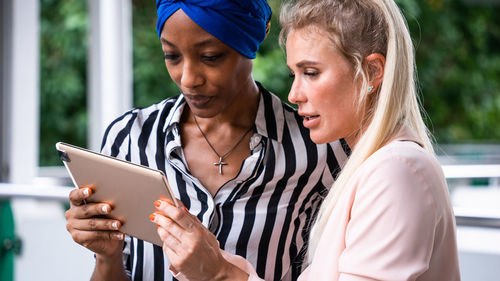 Midsection of woman holding smart phone outdoors