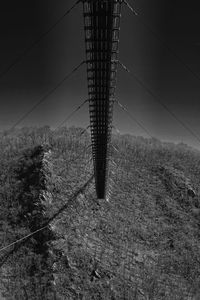 Electricity pylon on field against sky