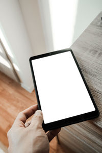 Low angle view of person using mobile phone on table