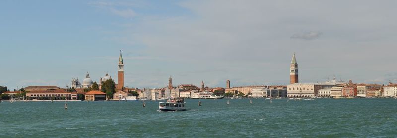 Boats in sea with buildings in background