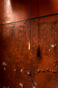 Close-up of red light hanging against built structure