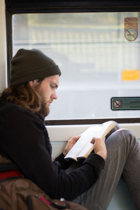 Man reading book in train