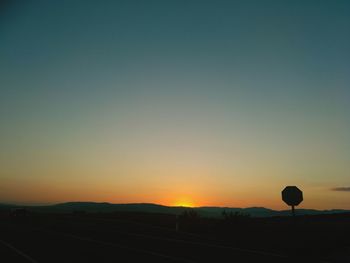 Silhouette landscape against clear sky during sunset