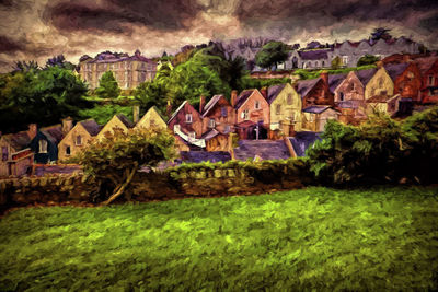 Houses by trees and buildings against sky