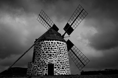 Low angle view of traditional windmill against sky