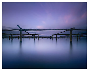 Pier over sea against sky at dusk