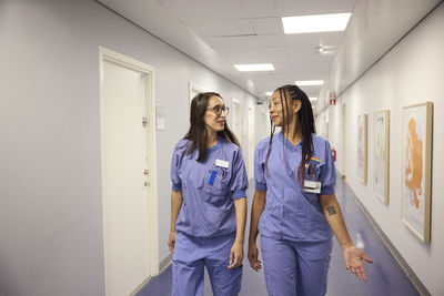 Female doctors talking in hospital corridor