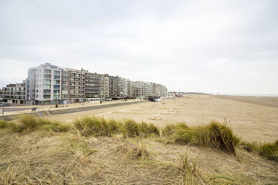 Buildings by sea against sky