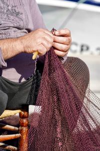 Midsection of man holding fishing net