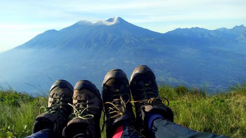 Low section of people on mountain against sky