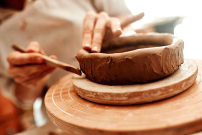 Midsection of man making pottery