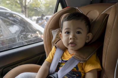 Close-up of little boy children on a car seat in the car.