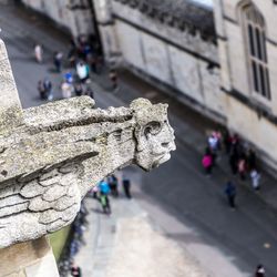 Close-up of old statue against building in city