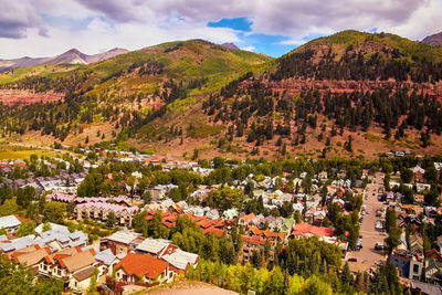 Aerial view of townscape and mountains against sky