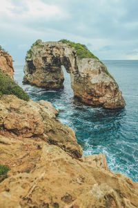 Rock formations in sea against sky