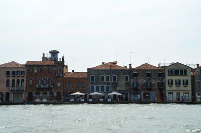 Buildings in city against clear sky during winter