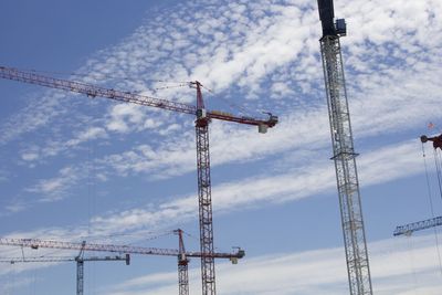 Low angle view of cranes against sky