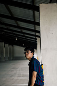 Portrait of young man standing in building corridor