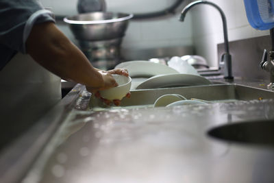 Midsection of person preparing in kitchen at home