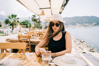 Portrait of young woman sitting at beach