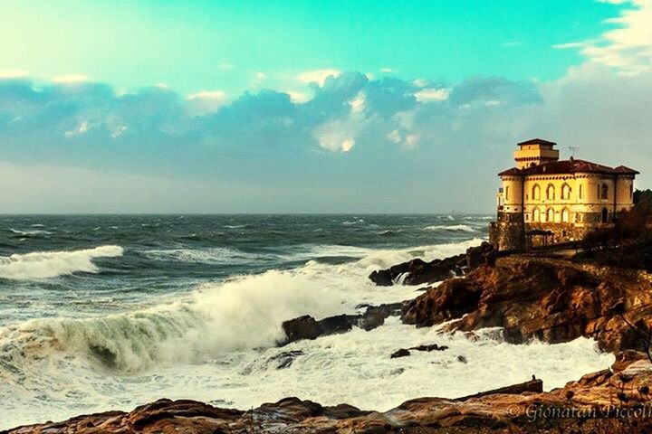 sea, water, horizon over water, wave, surf, sky, building exterior, built structure, architecture, scenics, rock - object, beauty in nature, shore, motion, beach, nature, cloud - sky, coastline, power in nature, splashing