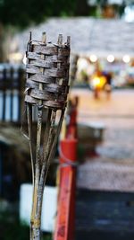 Close-up of cross on street by buildings in city