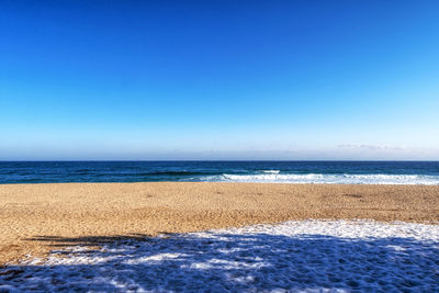 Scenic view of sea against clear blue sky