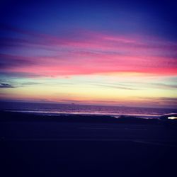 Scenic view of sea against dramatic sky during sunset