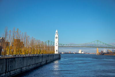 Bridge over river against clear blue sky