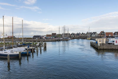 Sailboats moored in river against buildings in city