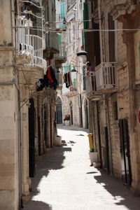 Rear view of woman walking on footpath amidst buildings