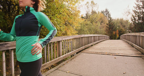 Young woman standing against trees