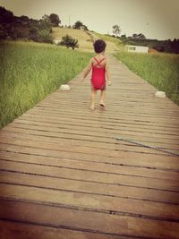 Rear view of woman walking on footpath