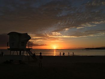 View of tourist on beach at sunset