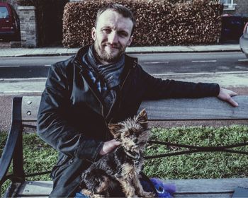 Portrait of man with dog sitting outdoors