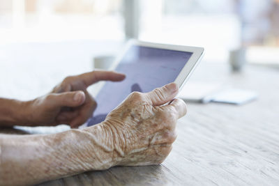 Woman's hand holding digital tablet, close-up