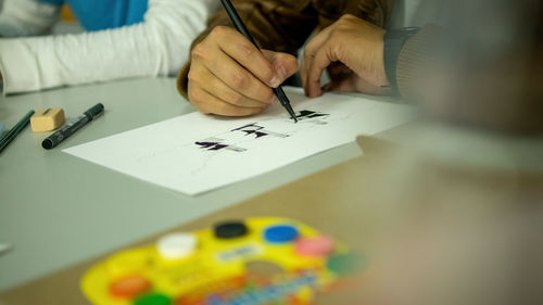 Person drawing by hand with pen, pencil and ink, architectural perspectives, in color.