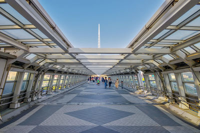 People walking on elevated walkway in city