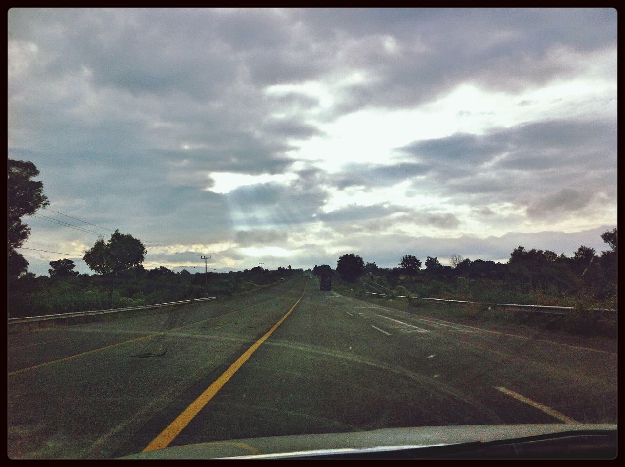 transportation, transfer print, road, sky, the way forward, road marking, auto post production filter, cloud - sky, diminishing perspective, country road, car, mode of transport, landscape, land vehicle, vanishing point, tree, cloudy, cloud, field, windshield