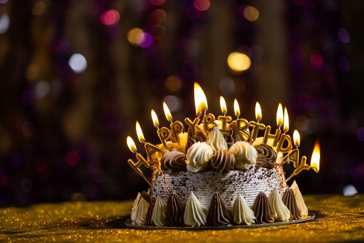 CLOSE-UP OF ILLUMINATED CANDLES ON BURNING