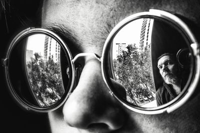 Reflection of man on sunglasses worn by person