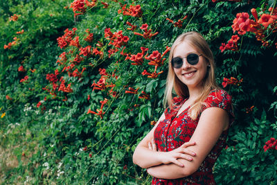 Portrait of a smiling young woman against plants