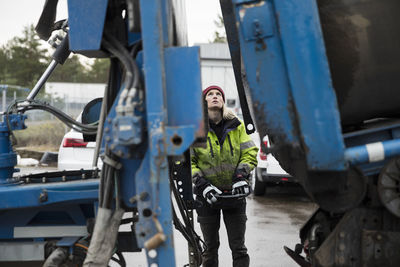 Young female construction worker operating machinery